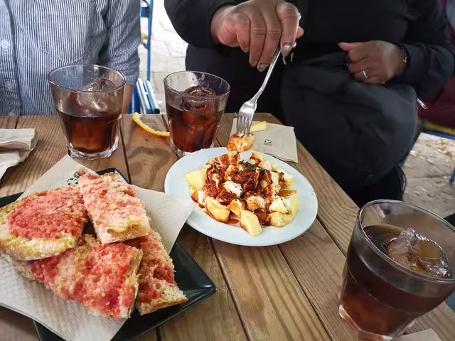 Guests enjoying traditional tapas and wine on a private Barcelona tour with dishes like patatas bravas and pan con tomate.