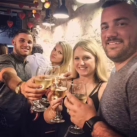 Group of friends enjoying wine and tapas at a cozy Barcelona tavern on a private tour, capturing local culinary delight.