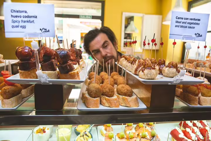 A man examines a vibrant display of traditional Spanish tapas at a Barcelona tavern during a private wine and tapas tour.