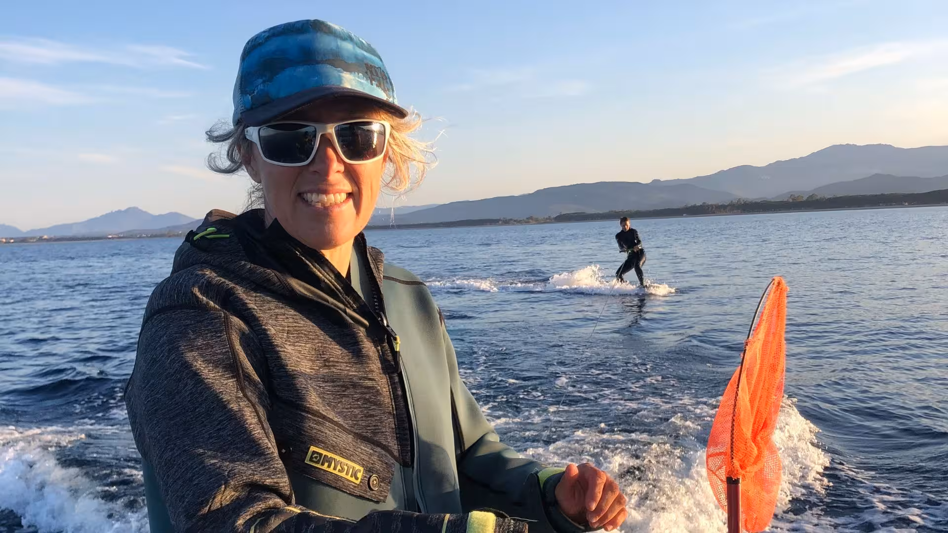 Instructor guiding wakeboarding session in Bari Sardo, showcasing picturesque Sardinian coastline and adventure.