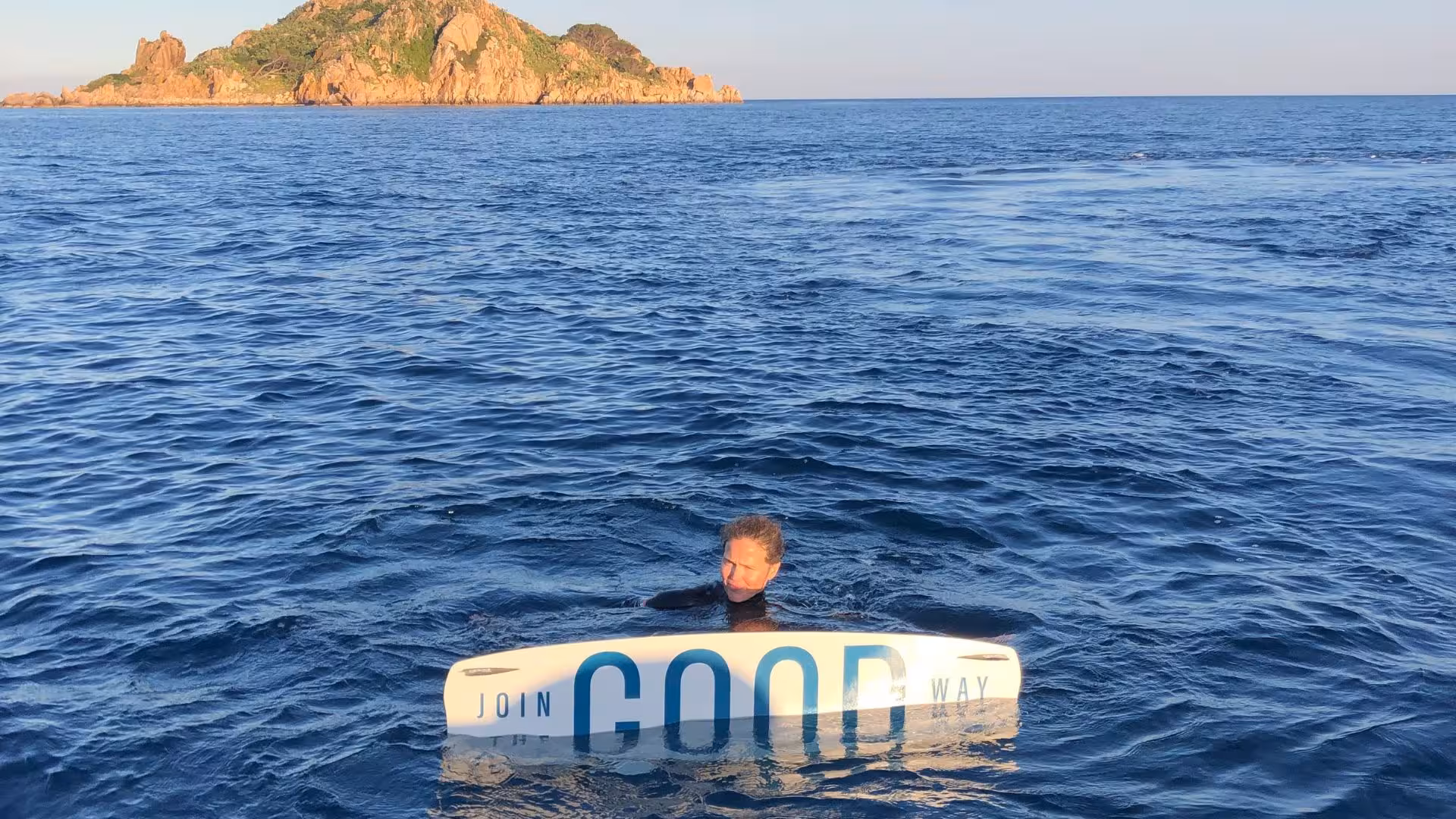Wakeboarder in Bari Sardo waters with scenic island backdrop, ideal for thrilling water sports enthusiasts.