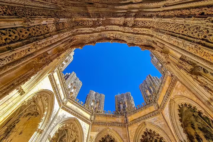 Intricate Gothic architecture of Batalha Monastery under a clear blue sky, featured in a 3-day Portugal World Heritage tour.