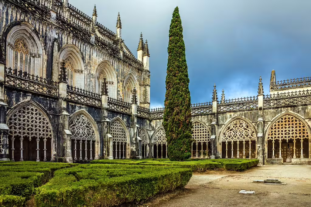 Gothic architecture of Batalha Monastery, Portugal, highlighted in a lush garden setting, perfect for a self-drive tour.