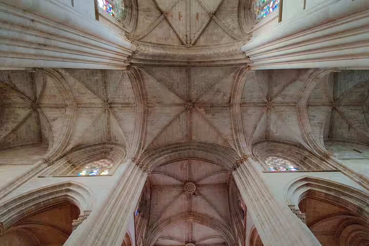 Intricate Gothic architecture of Batalha Monastery's vaulted ceiling, featured on a private day tour to Fatima, Nazaré, and Obidos.