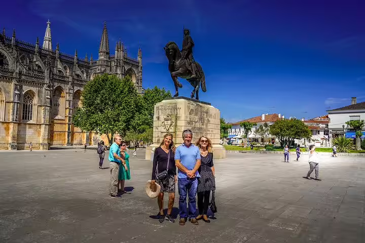 Visitors explore the historic Batalha Monastery and equestrian statue on a sunny day during a 3-day Portugal World Heritage tour.