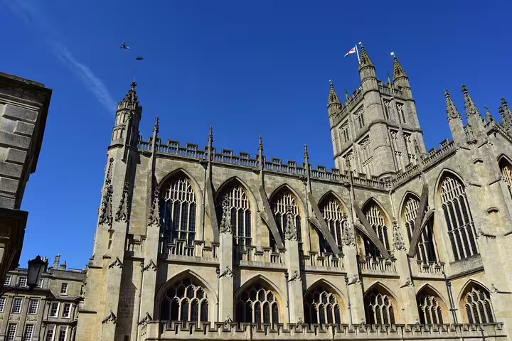 Bath Abbey Gothic facade under blue sky on London to Windsor Castle, Stonehenge and Bath private day tour