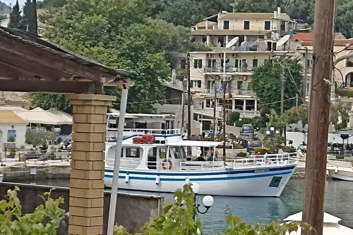 Local BBQ boat moored in an Ionian Sea harbor village, ideal for authentic coastal cruise trips
