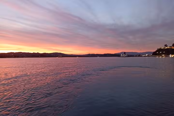 Pink twilight over the Ionian Sea from a locals BBQ boat tour, wide open water and coastal skyline