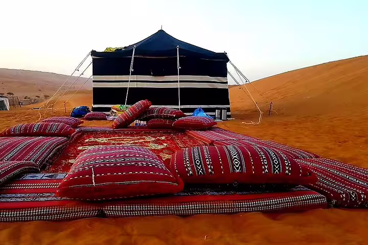 Experience traditional Bedouin hospitality at a desert camp in the Wahiba Sands, Oman.