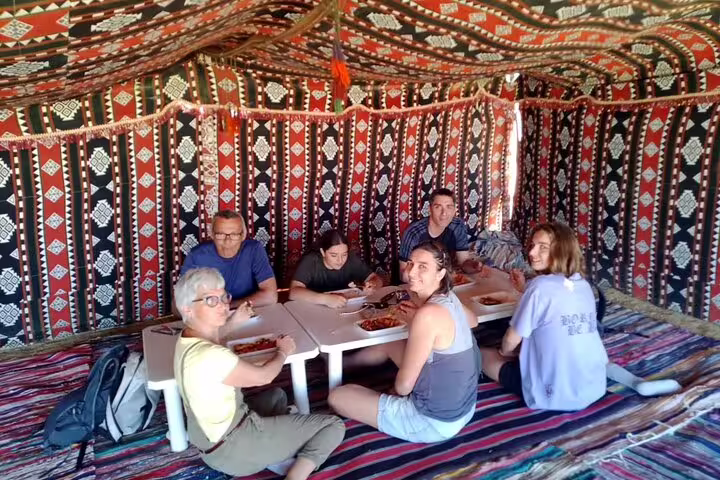 Travelers sharing lunch inside a Bedouin tent in Bahariya Oasis, Egypt, on a 4-day private desert adventure
