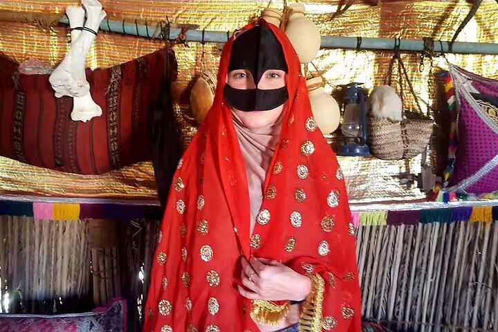 Person in traditional attire inside a Bedouin tent, experiencing Omani culture on a 2-Day Wahiba Sands Tour from Muscat.