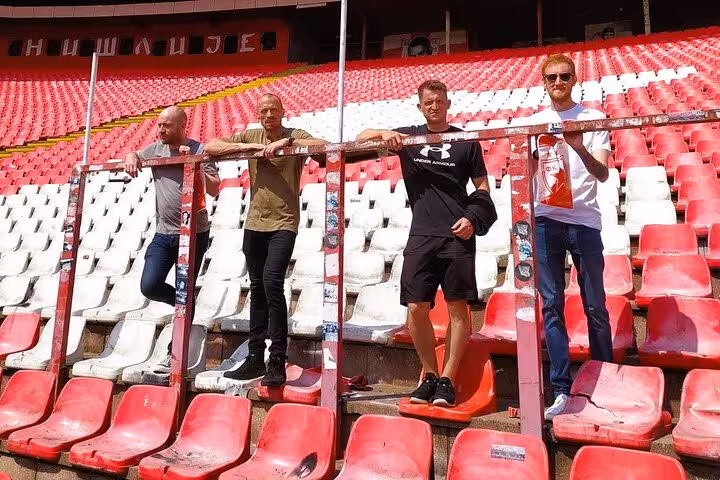 Local guide and guests inside Rajko Mitic Stadium stands before Belgrade football match live experience