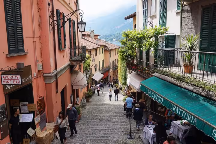 Bellagio old town cobblestone lane with trattorias, a stop on guided Lugano and Lake Como cruise tour