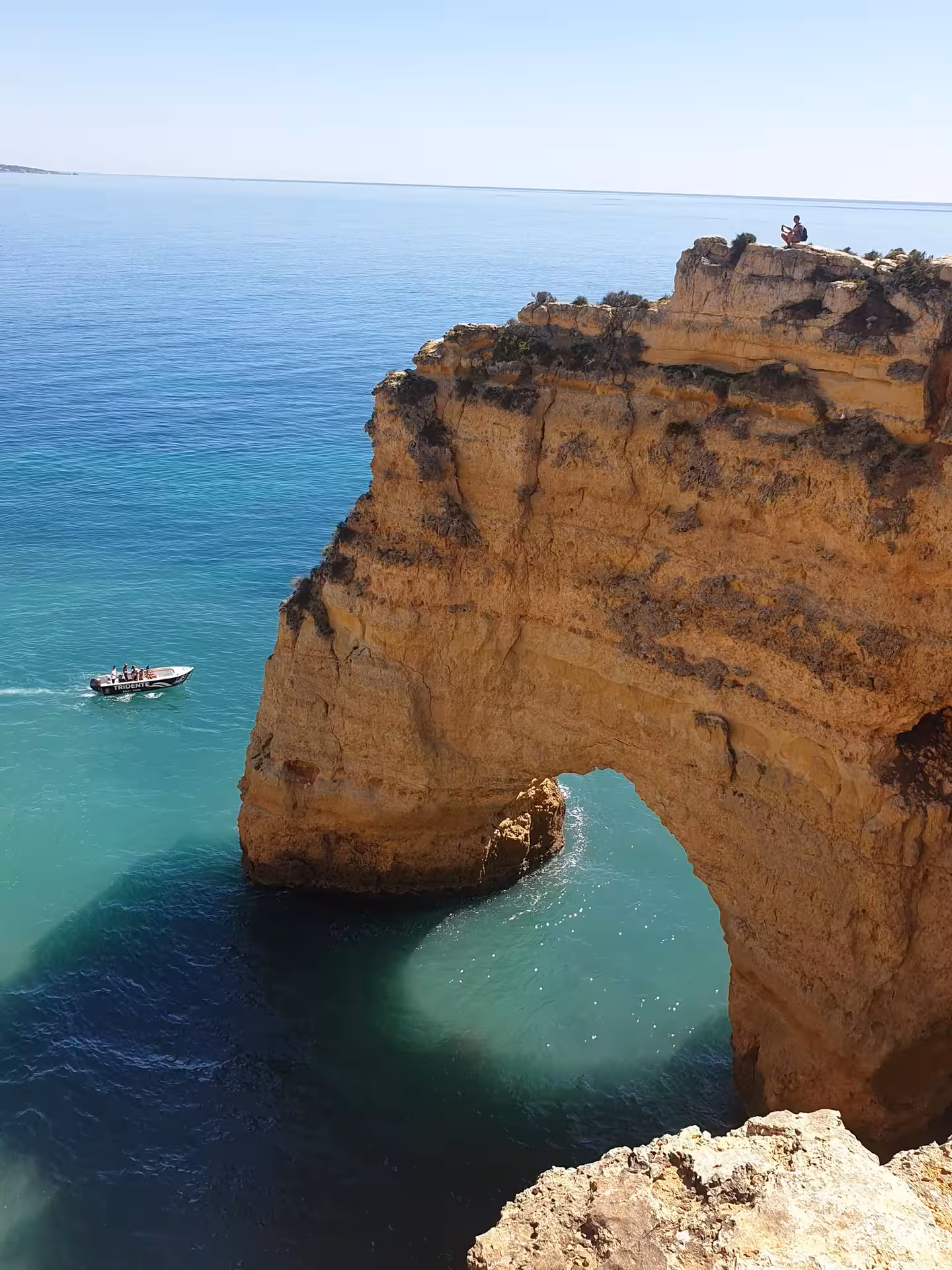Tour boat cruising beneath a towering sea arch on a private 1-hour Benagil Cave tour along Portugal’s Algarve coast