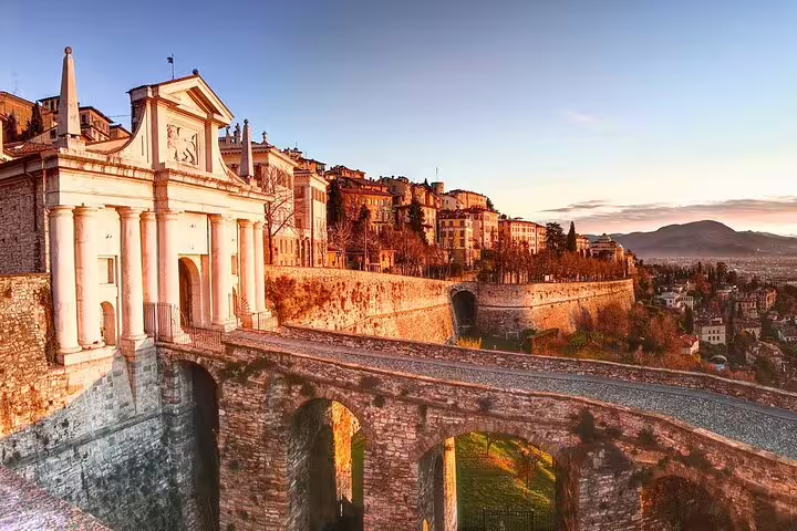 Sunset over Porta San Giacomo and Venetian walls of Bergamo Alta, key stop on a 2.5-hour private Bergamo walking tour