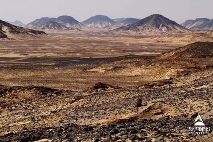Vast Black Desert volcanic landscape in Egypt, part of 5-day Djara Cave and desert camping adventure