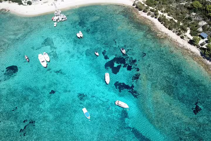 Aerial view of turquoise bay with boats near sandy beach on Blue Cave and 5 Islands tour from Split