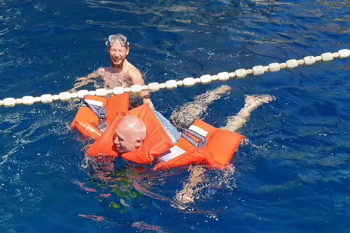 Guests floating in life jackets during Blue Cave & 5 Islands tour swim stop in crystal-clear Adriatic sea