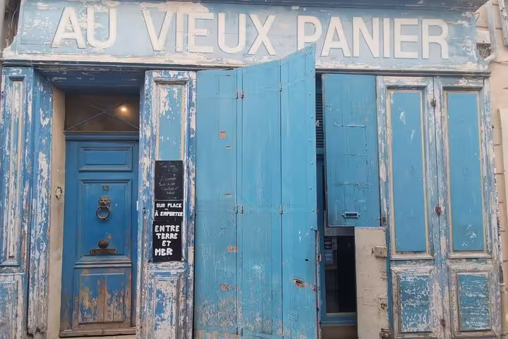 Weathered blue Au Vieux Panier doorway in Le Panier, Marseille, near petanque tour meeting point