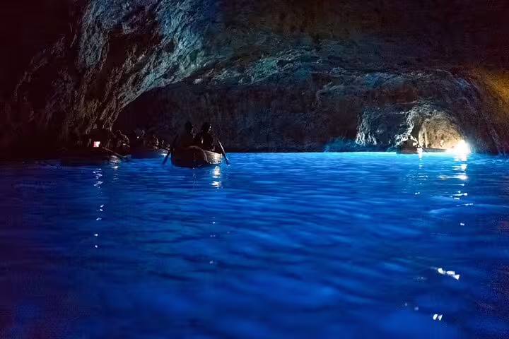 Blue Grotto-style sea cave with glowing water on a private classic boat tour in Capri, exploring island caves