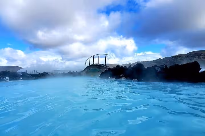 Scenic view of Blue Lagoon's turquoise waters under a cloudy sky, perfect for a relaxing geothermal spa experience.