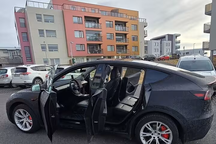 Luxury vehicle parked in Reykjavik with vibrant buildings, ideal for a comfortable Blue Lagoon transfer experience.