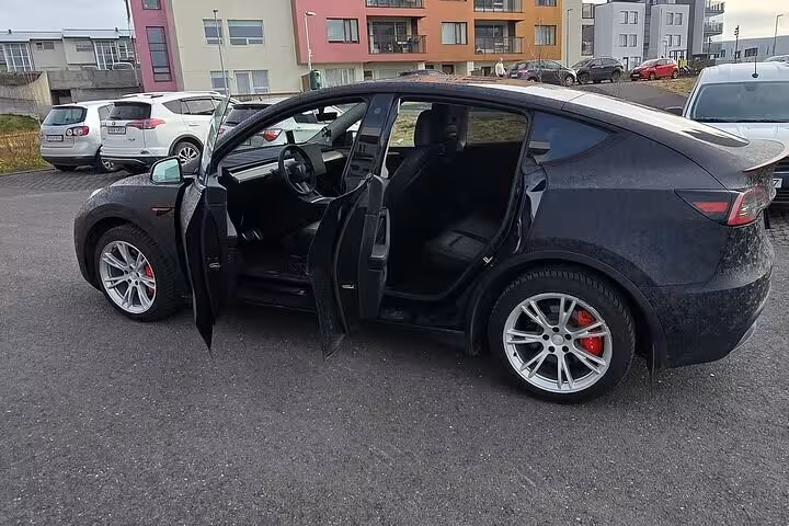 Sleek black car with open doors in Reykjavik, ready for Blue Lagoon private transfer, showcasing modern comfort and style.