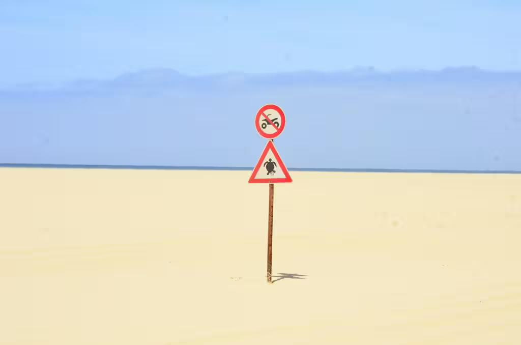 Sign indicating protected turtle nesting area on sandy beach, highlighting eco-friendly aspects of Boa Vista tours.