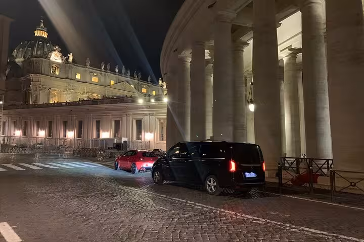 Elegant van parked by historical columns at night, showcasing luxury transfer from Bologna to Ravenna cruise port.