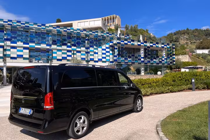 Luxurious black van parked outside modern building for Bologna to Ravenna cruise terminal transfer service.