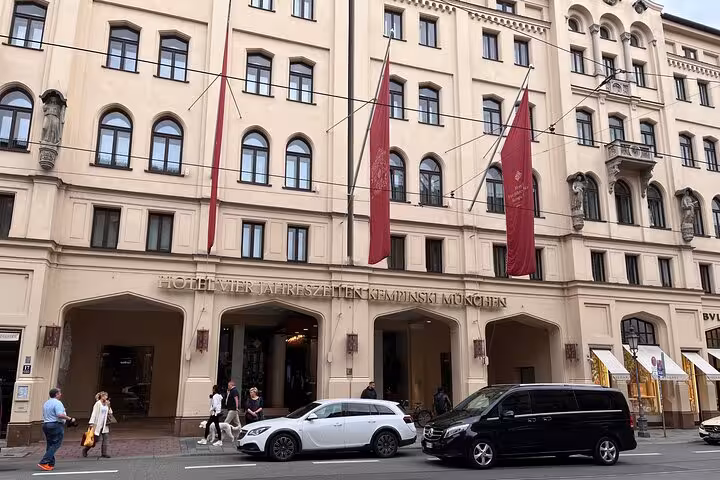 Elegant city street view with luxury cars outside a historic European hotel, ideal for Bologna to Ravenna transfer.