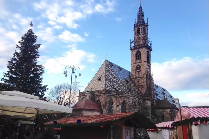 Bolzano Cathedral and Christmas market stalls, key stop on a Bolzano self-guided scavenger hunt tour