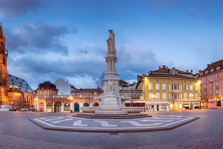 Evening view of Waltherplatz statue in Bolzano, a key stop on the self-guided scavenger hunt and highlights tour