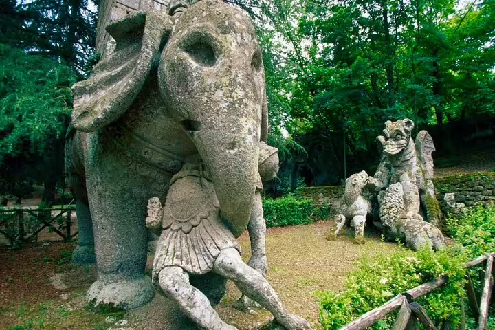 Surreal stone elephant and warrior sculptures in Bomarzo Monster Park on the Rome Calcata Bomarzo VIP guided tour