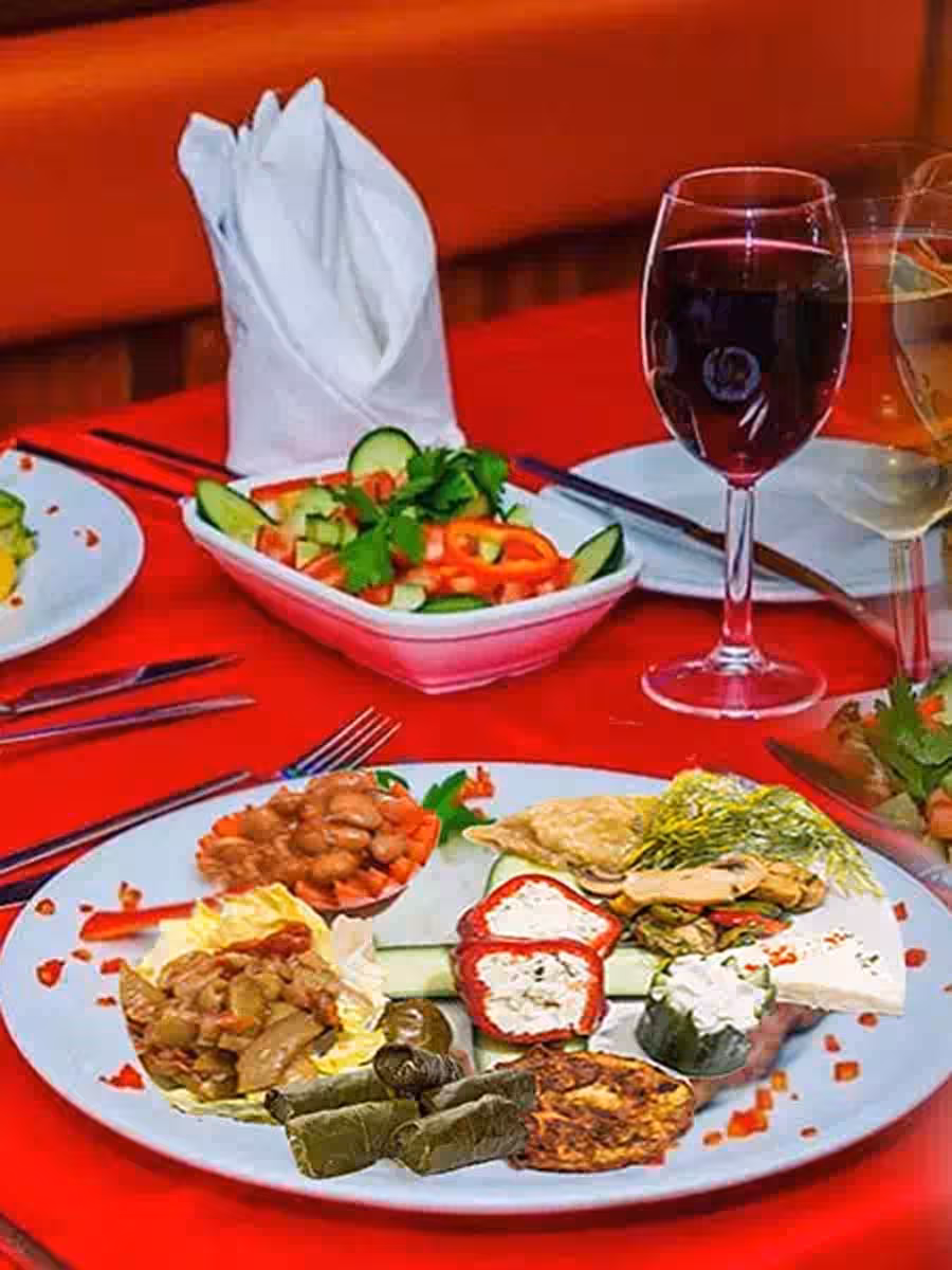Turkish meze platter and salad with wine on a Bosphorus dinner cruise in Istanbul, red table setting
