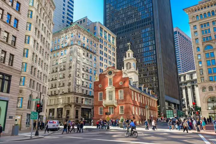 Old State House surrounded by modern skyscrapers on a busy Boston street with pedestrians