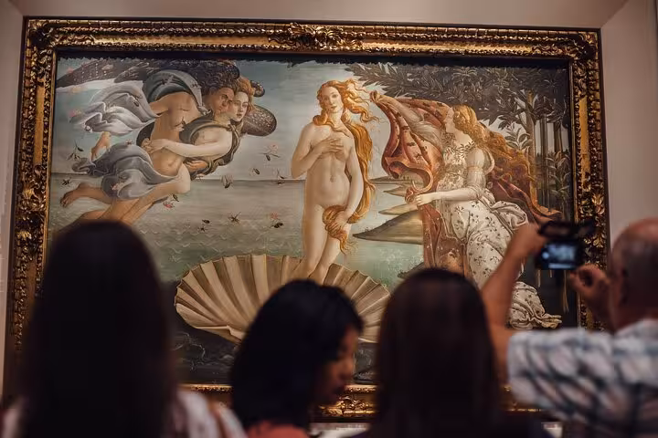 Visitors admire Botticelli's Birth of Venus during Accademia and Uffizi small-group tour in Florence.