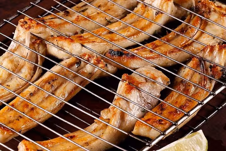 Grilled Brazilian barbecue ribs sizzling on a grill for a Rio dinner experience.