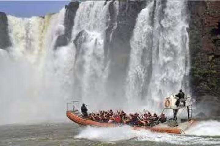 Adventurous boat tour navigates close to the powerful Brazilian Falls, offering an exhilarating experience for visitors.
