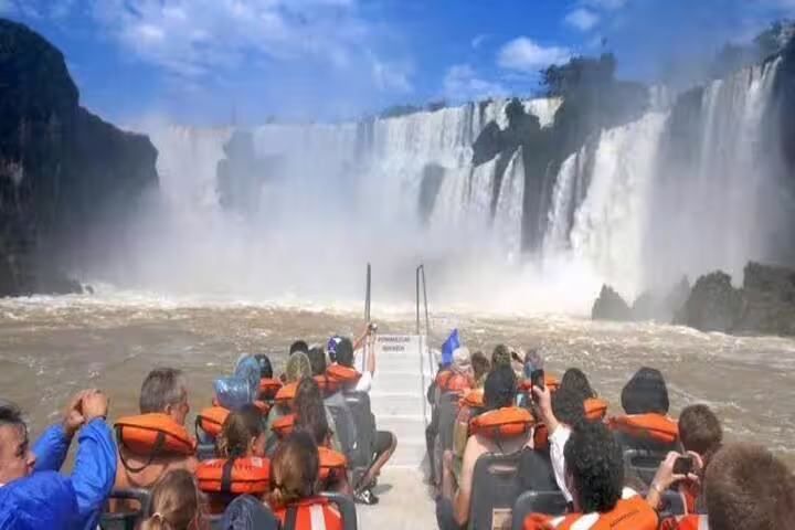Tourists on a thrilling boat ride experience the majestic power of the Brazilian Falls up close.