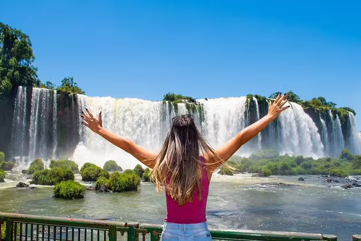 Visitor enjoys breathtaking views of the Brazilian Falls, embracing the natural beauty on a sunny day.
