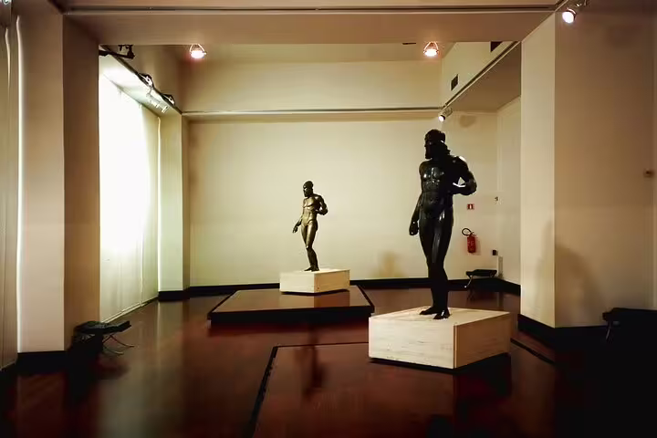 Bronze Greek statues displayed in a modern gallery at the National Archaeological Museum of Reggio Calabria on a private tour