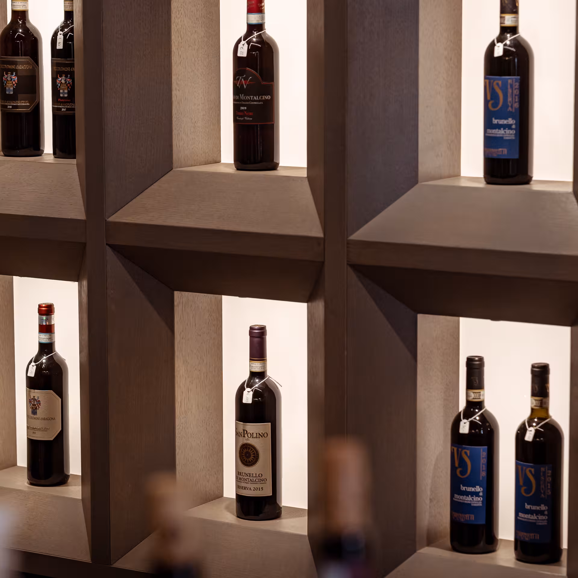 Explore a curated selection of Brunello di Montalcino wines displayed elegantly on wooden shelves.