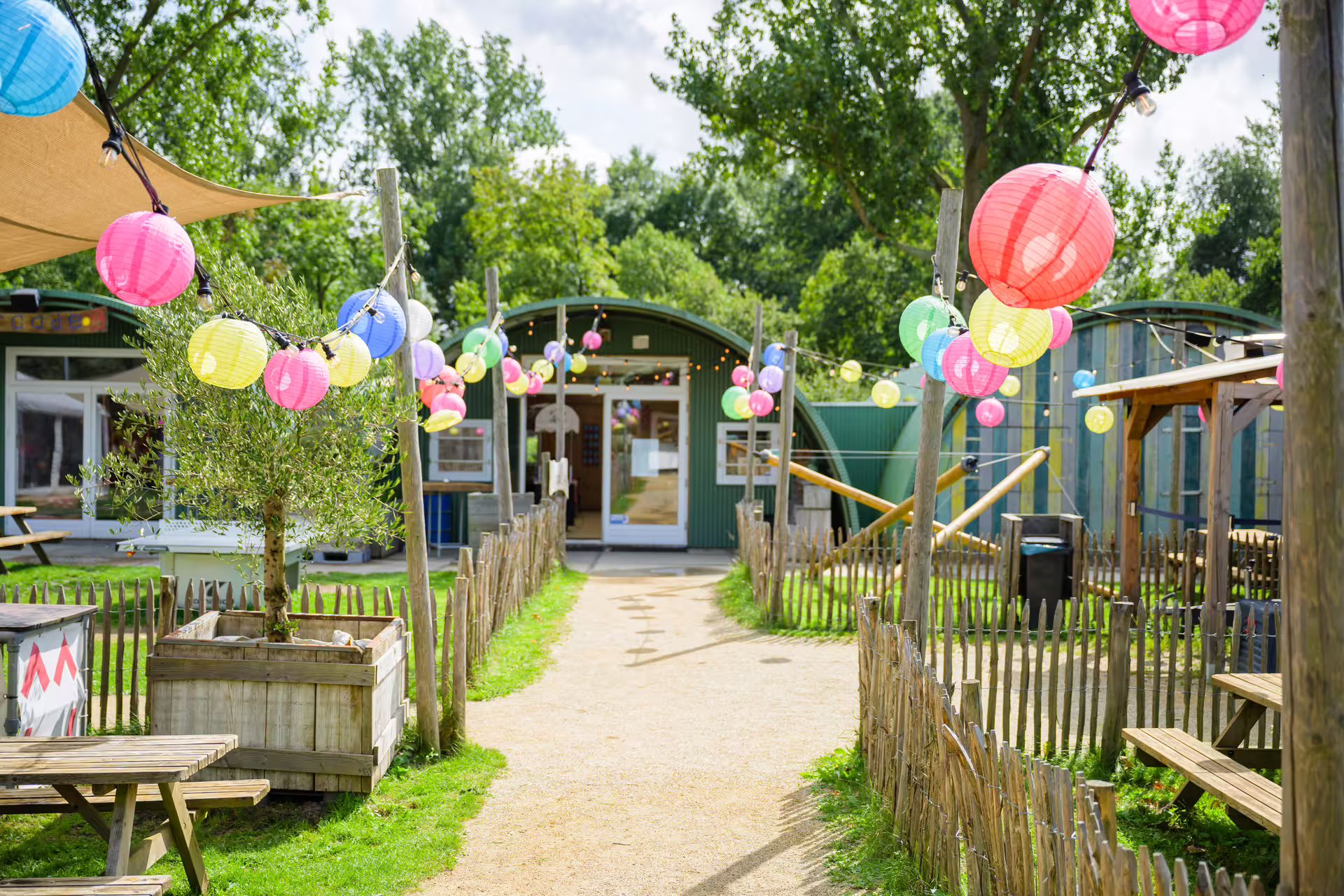 Outdoor venue for bubble football in Amsterdam with colorful lanterns, picnic benches and green park setting