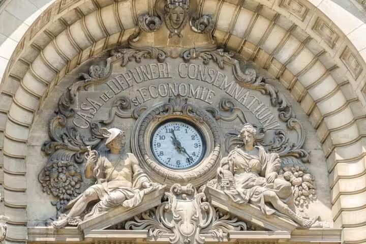 Ornate facade of Casa de Depuneri Consemnatiuni si Economie building in Bucharest with clock and stone sculptures