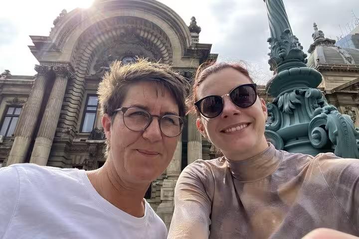 Two women taking a selfie in front of a grand historic building in Bucharest