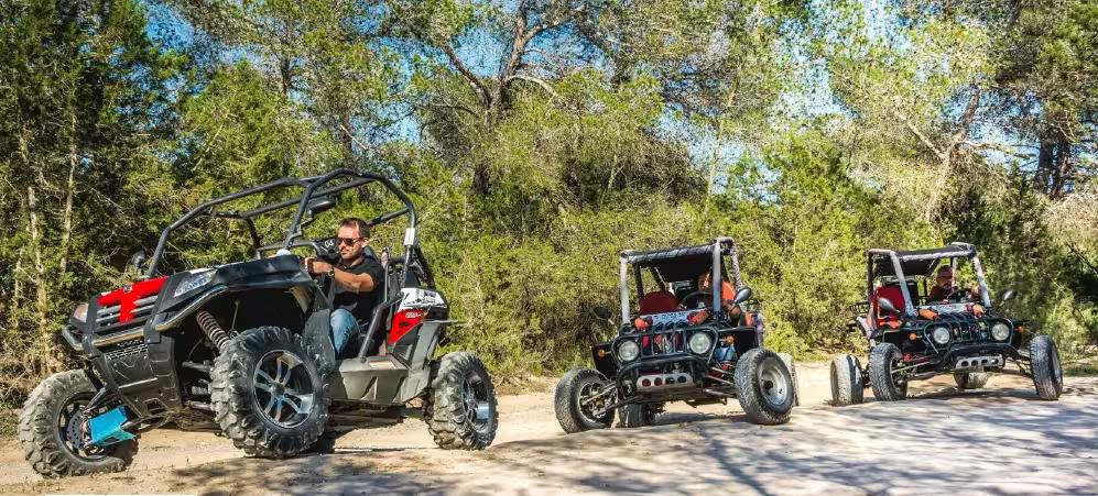 Convoy of buggies on dirt road in southern Ibiza, exploring Salinas Natural Park on a day trip tour