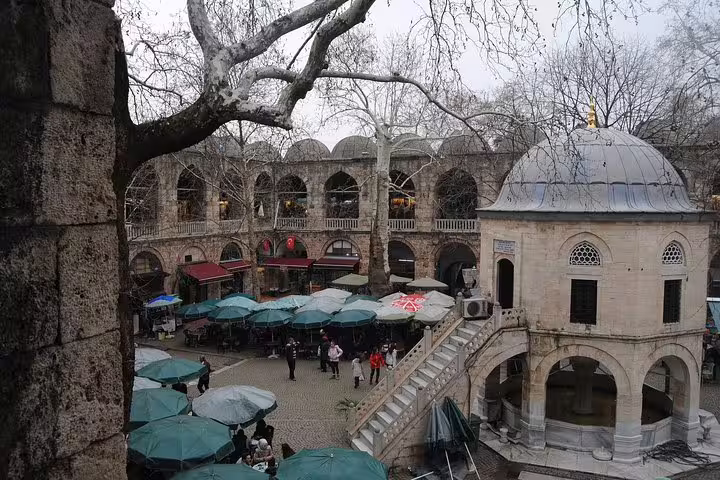 Courtyard of Bursa Koza Han silk bazaar with umbrellas and Ottoman pavilion on Istanbul to Bursa day tour