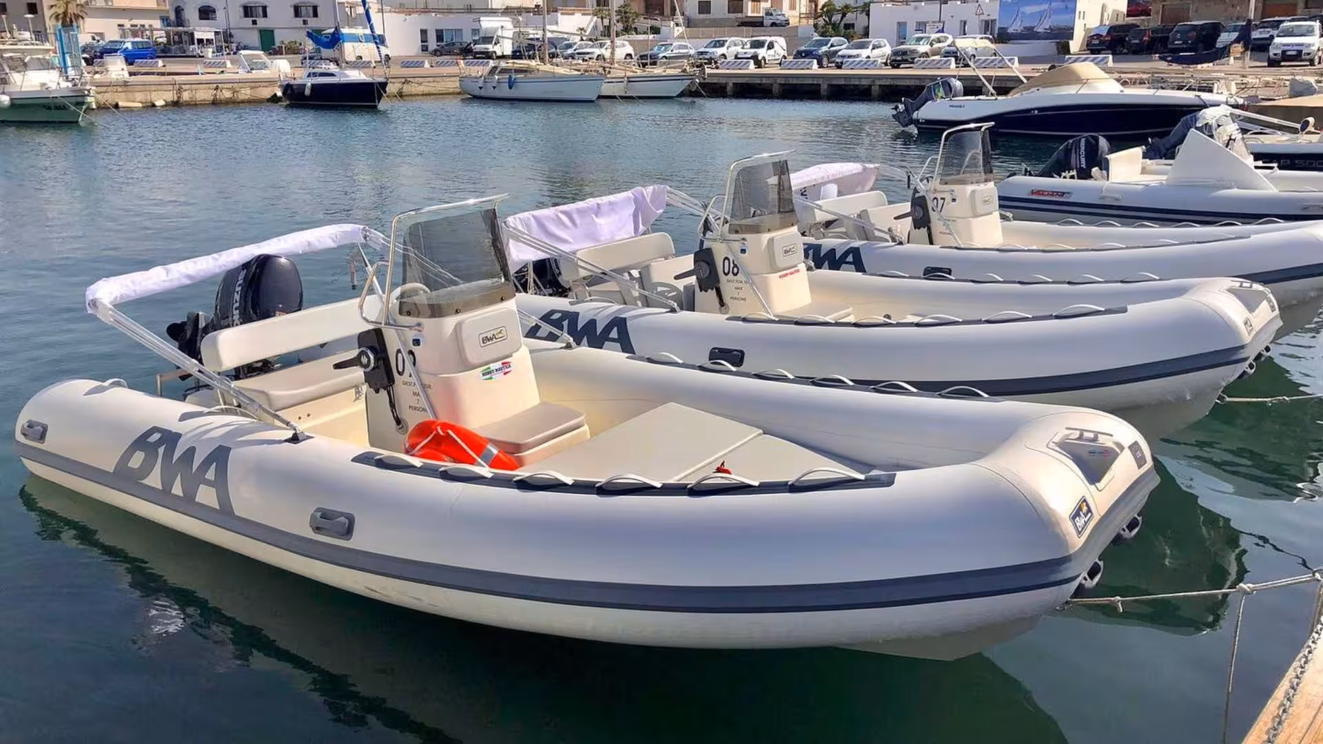 Line of BWA RIB boats docked at Calasetta marina, showcasing premium hire options for coastal adventures.