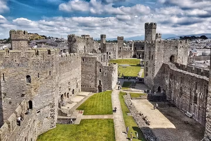 Inside Caernarfon Castle walls with green courtyard views, featured on Portmeirion and Snowdonia tour
